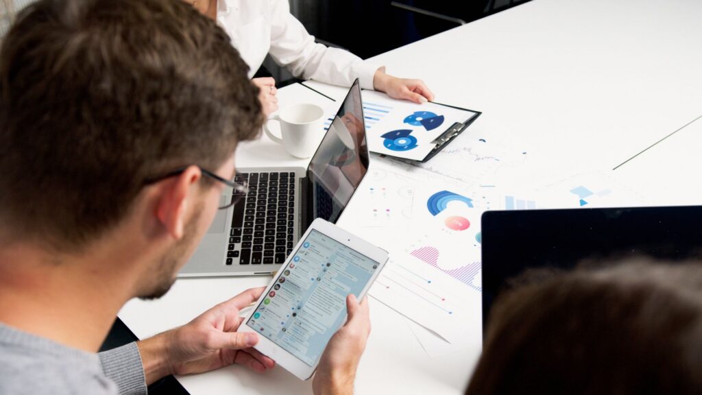 Business team reviewing charts and data on laptops, representing enterprise AI agent adoption