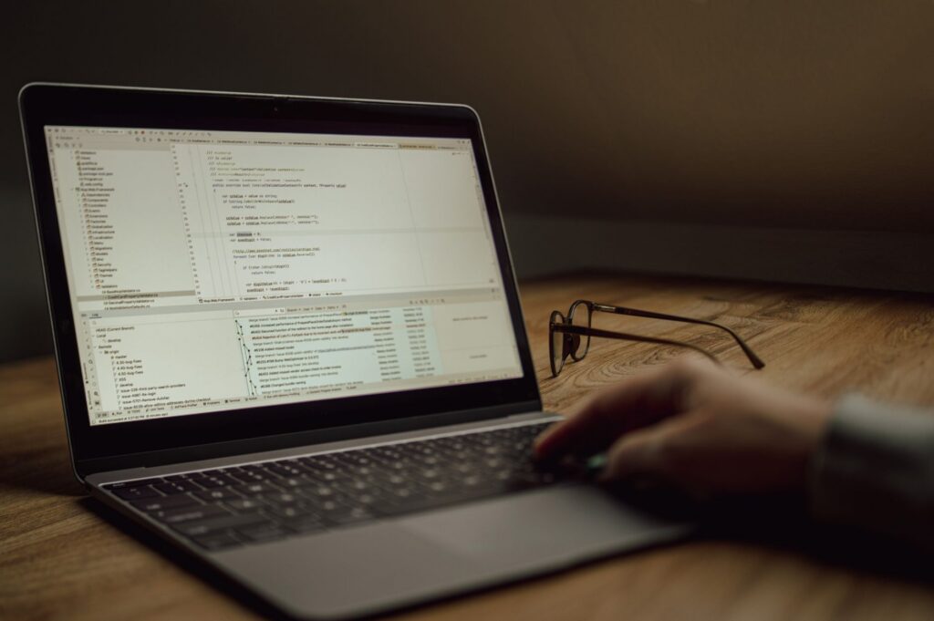 Person working on programming code on a laptop
