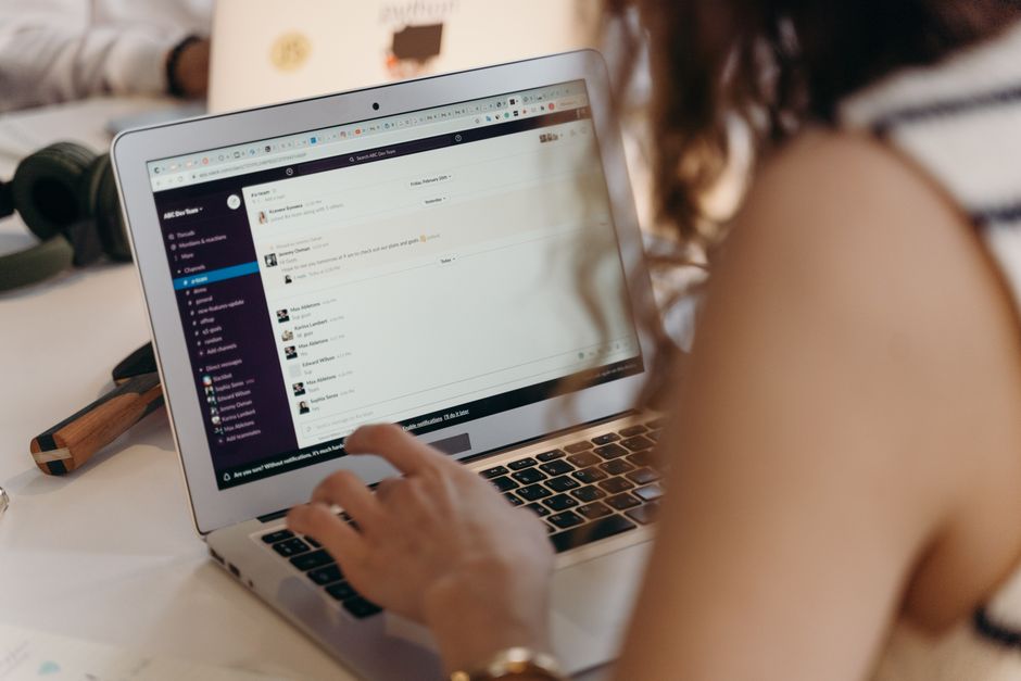 Businesswoman working on a laptop in an office using Slack